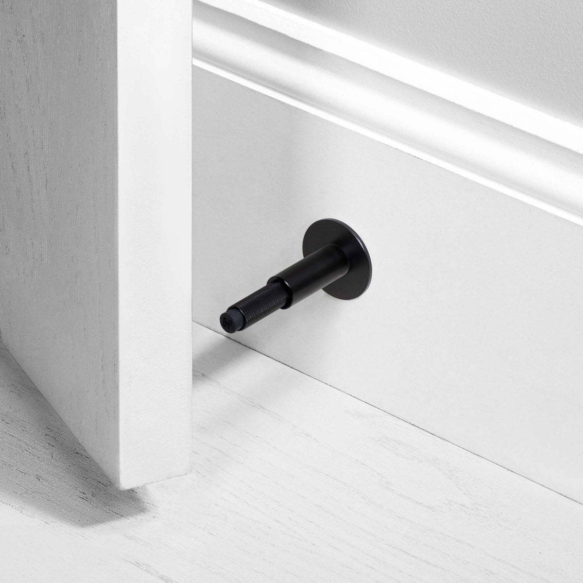 Buster + Punch Cross deurstopper wandmontage black - vooraanzicht
