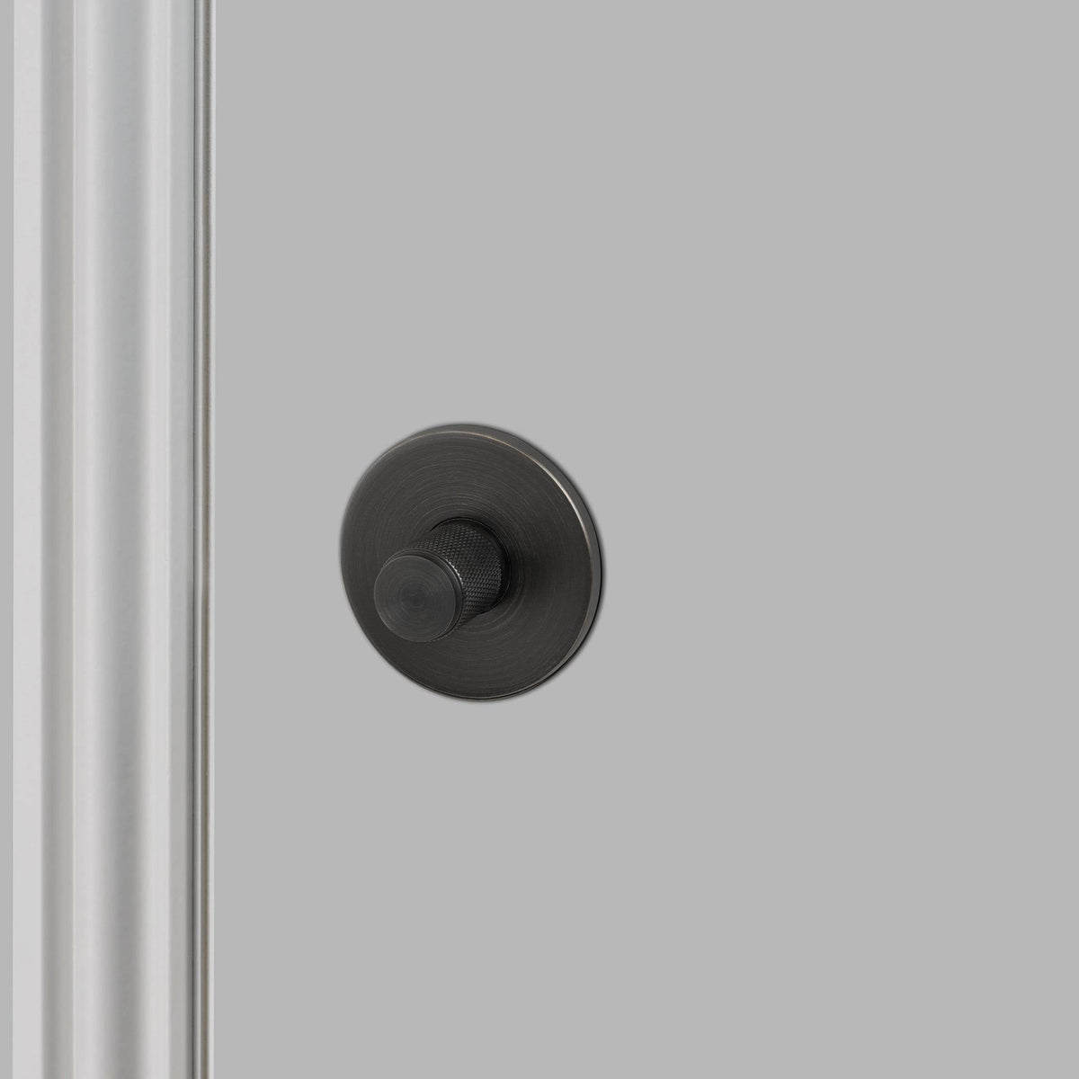 Buster + Punch Cross thumbturn WC-slot in smoked bronze, vooraanzicht